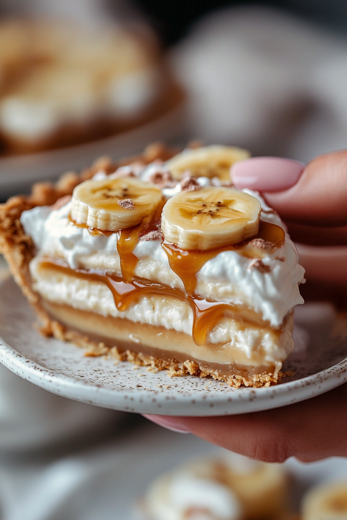 Slice of Traditional British Banoffee Pie with caramel, bananas, and whipped cream